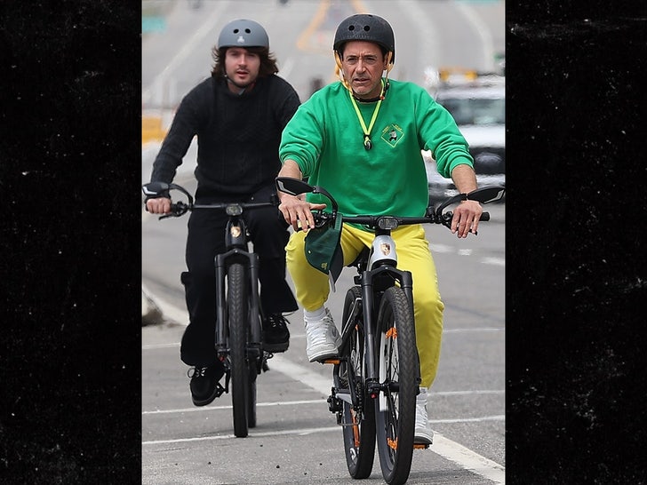 Robert Downey rides a bike with his 3rd son