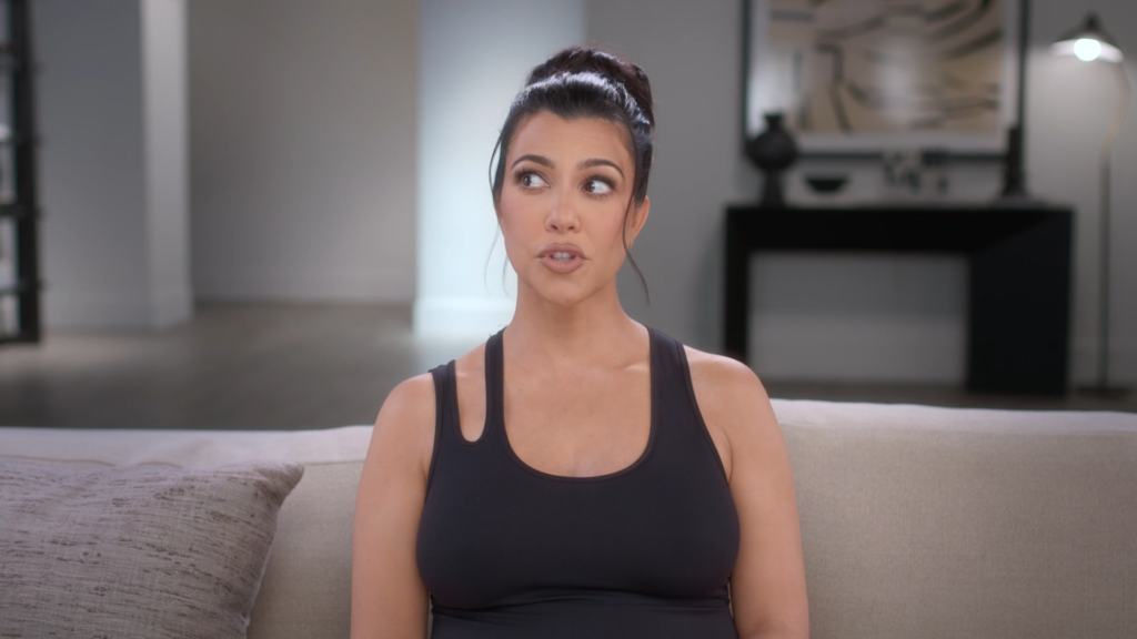 Kourtney Kardashian looks to the side with just her eyes while pregnant and speaks to the confessional camera on The Kardashians.