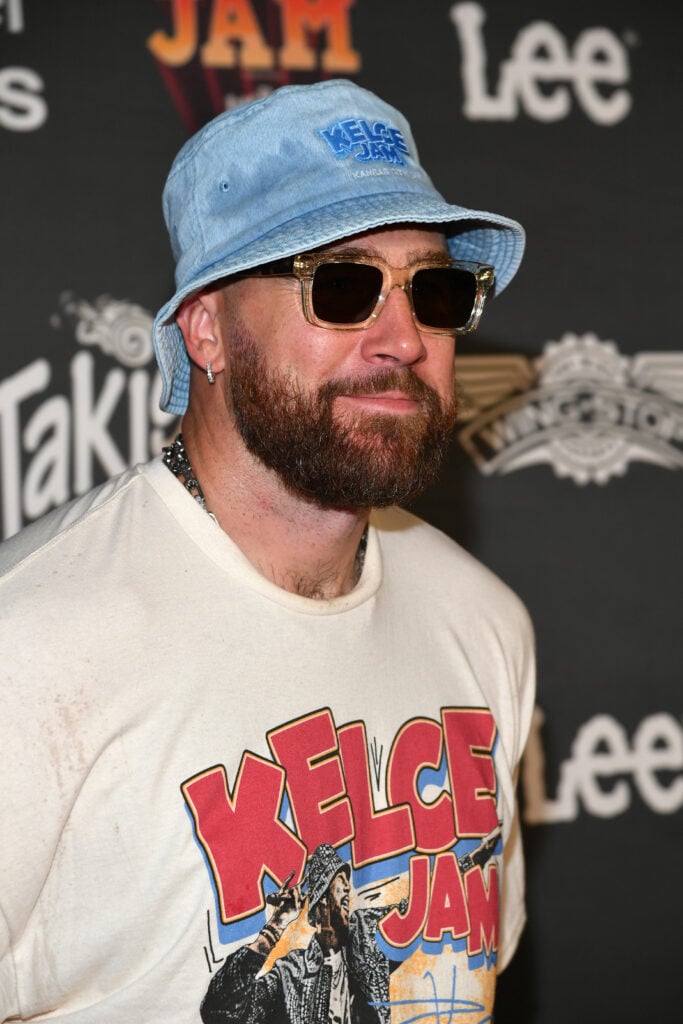 Travis Kelce in a silly fishing hat and glasses in 2024.