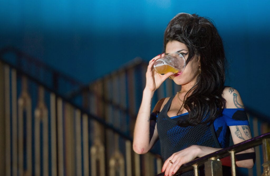 Amy Winehouse drinks a pint of beer while watching The Libertines perform live at The Forum on August 25, 2010 in London, England.  