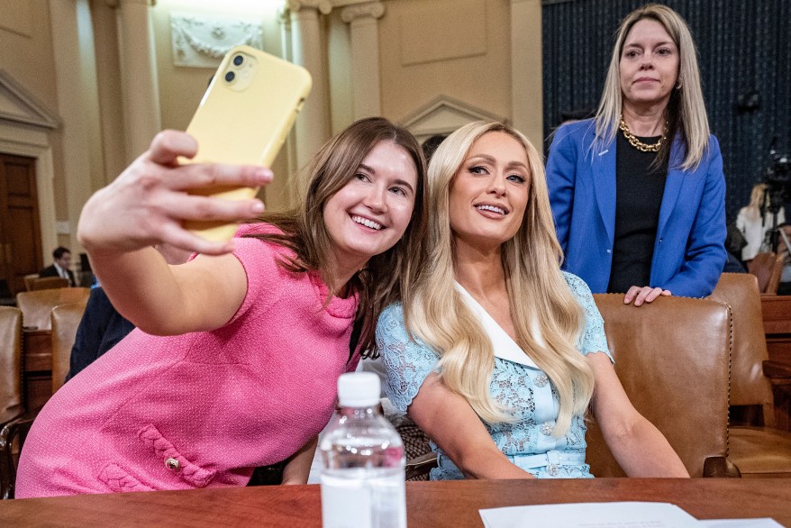 DEFEND YOUR SELFIE: Paris Hilton (right) takes a photo as she leaves to testify before Congress about alleged abuse she suffered in juvenile treatment facilities.