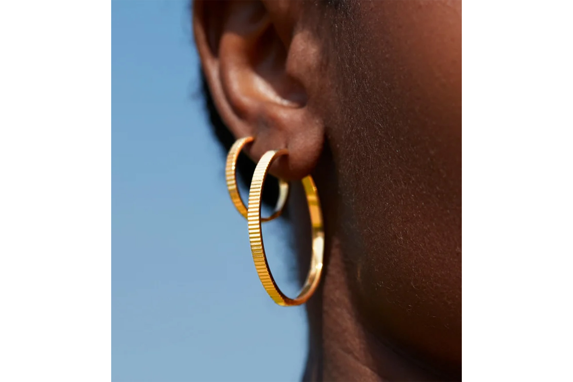 A model with gold hoop earrings