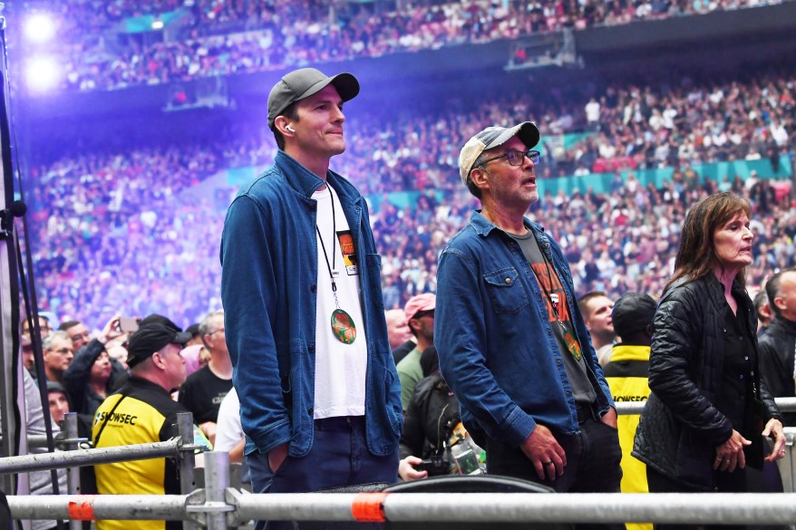 ashton kutcher standing at a concert with a friend