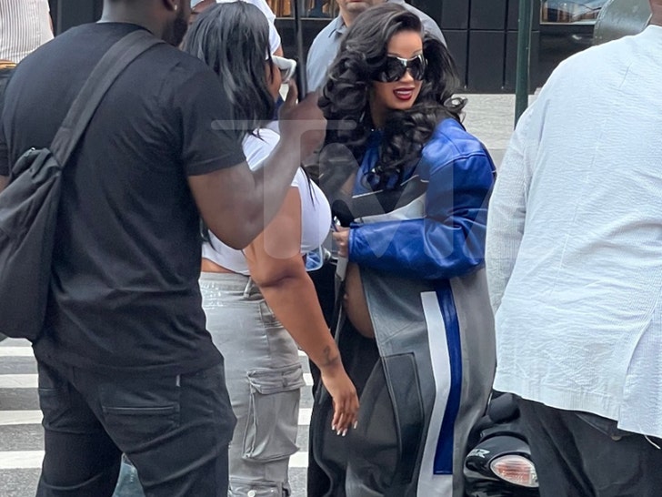 Cardi B covered by crew walking around NYC