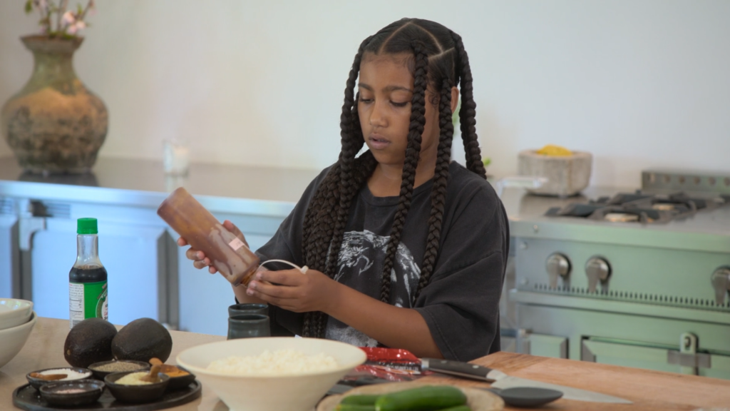 North West prepares food in her mother's spacious and eerily minimalist kitchen.