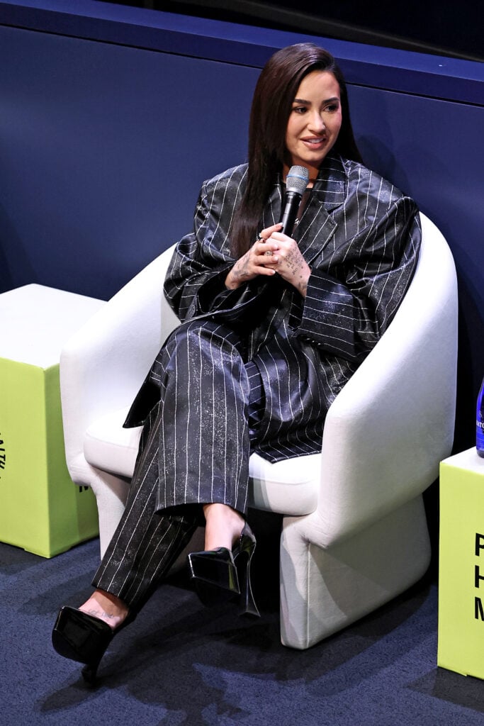 Demi Lovato speaks on stage during the Healthy Minds Project's World Mental Health Day Festival at Hudson Yards on October 10, 2024 in New York City.  