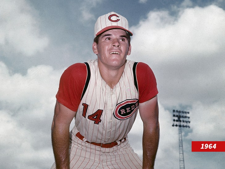 Pete Rose in a white striped Cincinnati Reds uniform hunched over the trash.